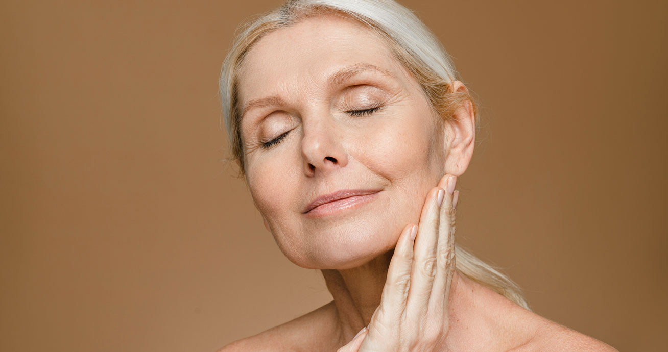 Mature-woman-touching-face-with-eyes-closed-portrait
