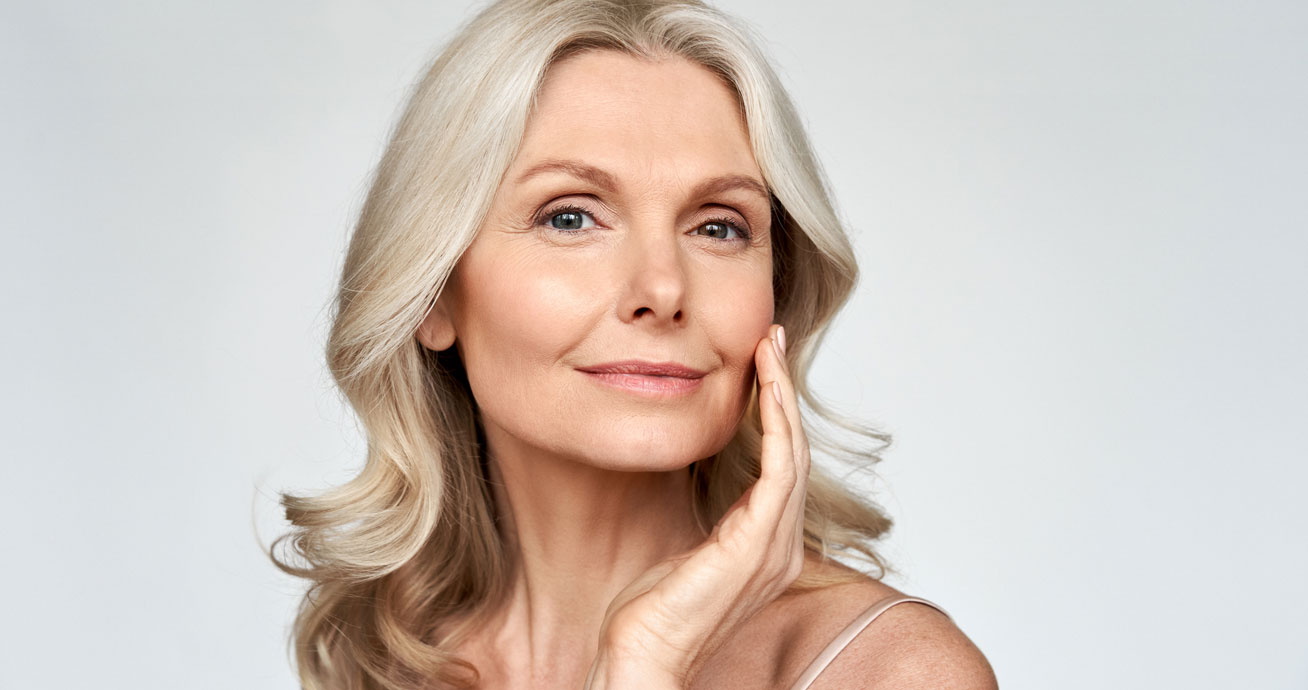 Smiling-mature-woman-touching-her-face-portrait