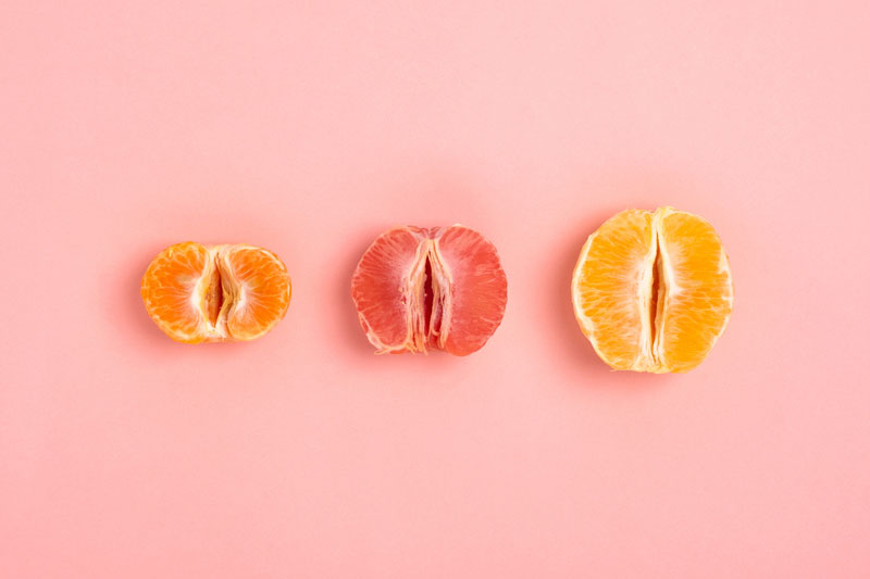 three-halved-citrus-slices-lined-up-on-a-pink-background