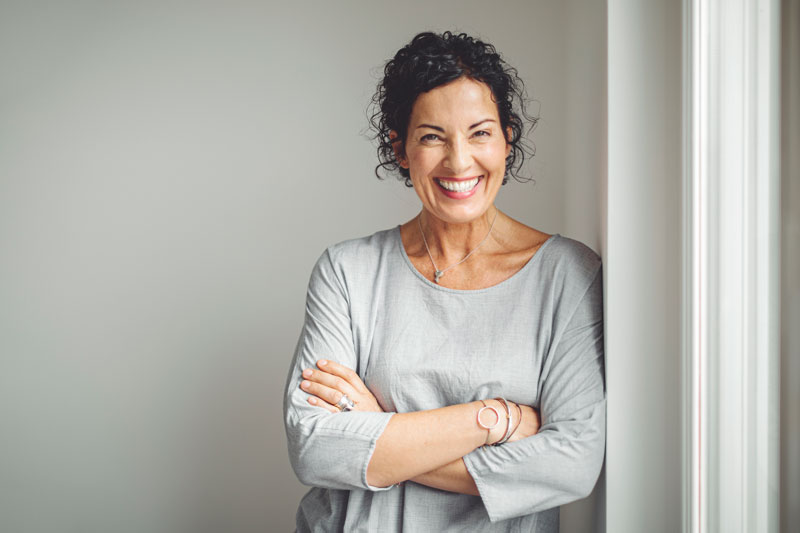 woman-standing-with-her-arms-crossed-beside-a-window